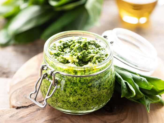 wild leek pesto with olive oil parmesan cheese glass jar wooden table